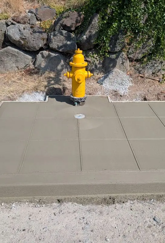 Concrete sidewalk and hydrant pad marked for removal, with sawcut lines around the hydrant.
